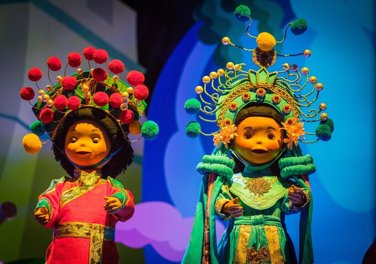 Artful dancers two dancing dolls from the small world are dressed in richly decorated costumes and magnificent hair ornaments