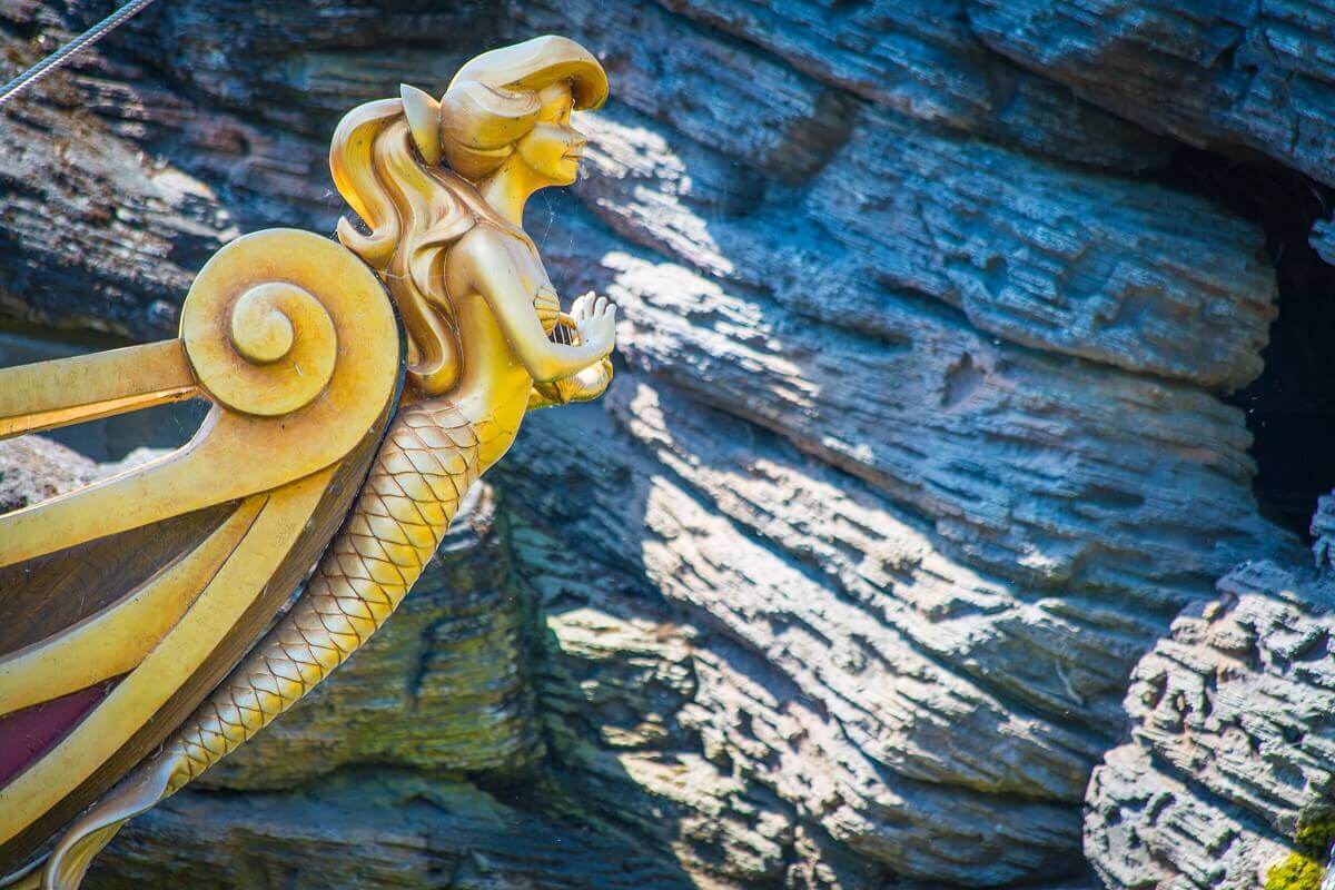 bow figure on a ship a golden figure of a mermaid is attached to the bow of a ship