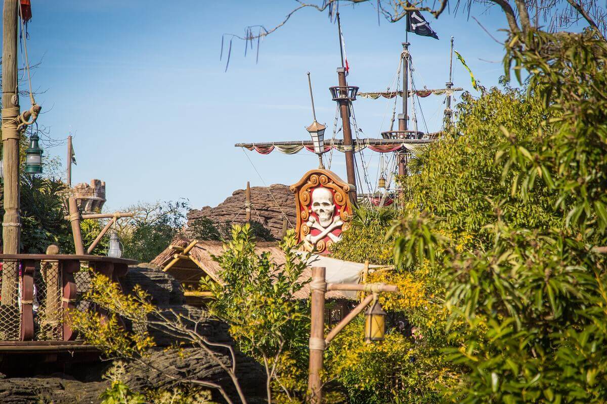 the pirate ship hidden behind plants View through a green thicket to Captain Hook's pirate ship