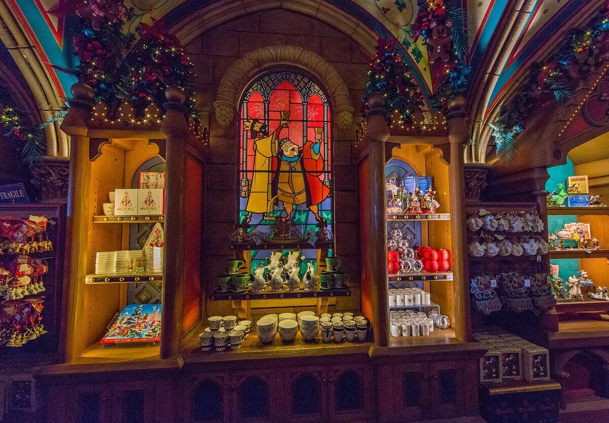 Glass windows and merchandise Among shelves of merchandise is a stained-glass window painting showing the two kings from Sleeping Beauty drinking together