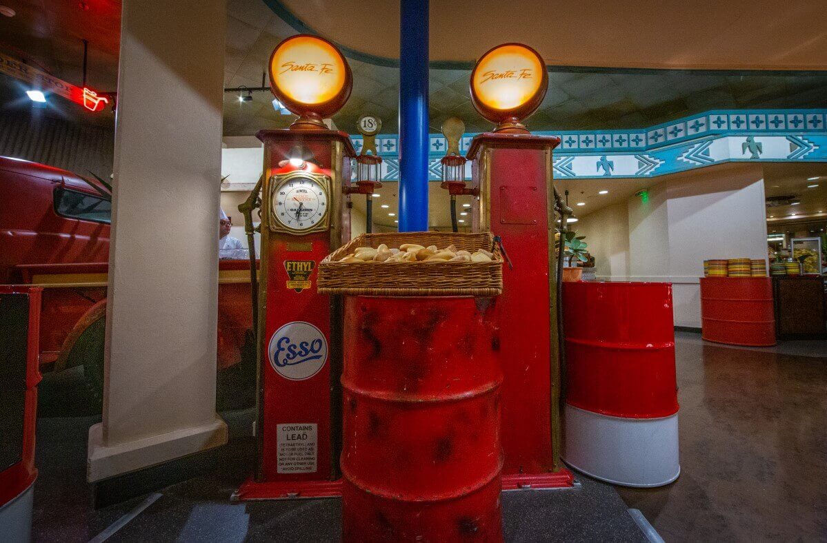 Decoration in the buffet area La Cantina Decoration in the form of a red gas pump in the restaurant, in front of it is a barrel with a basket of bread on it