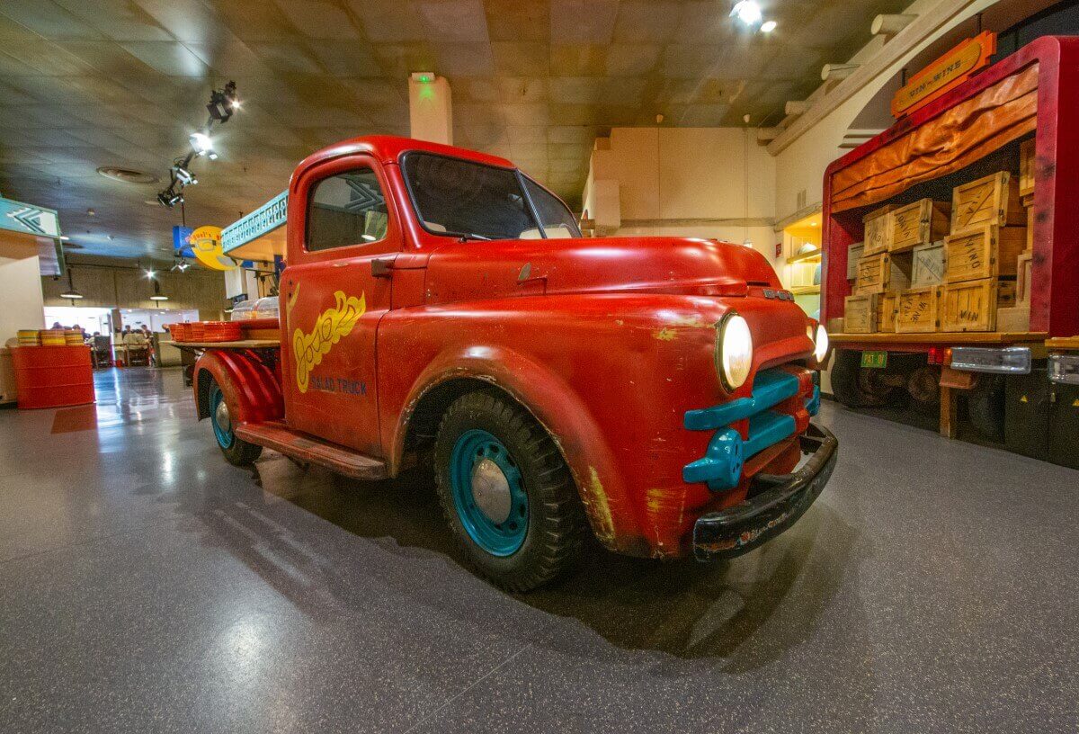 Decoration at La Cantina A red truck in the restaurant whose storage space is used for plates in the back