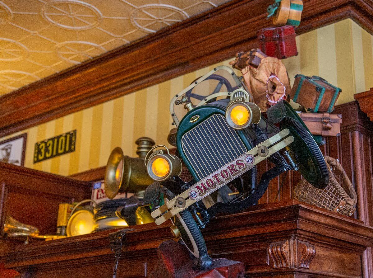 Model of a vintage car Model of a vintage car that appears to fall off the shelf as the loaded luggage tumbles out of the car in a high arc