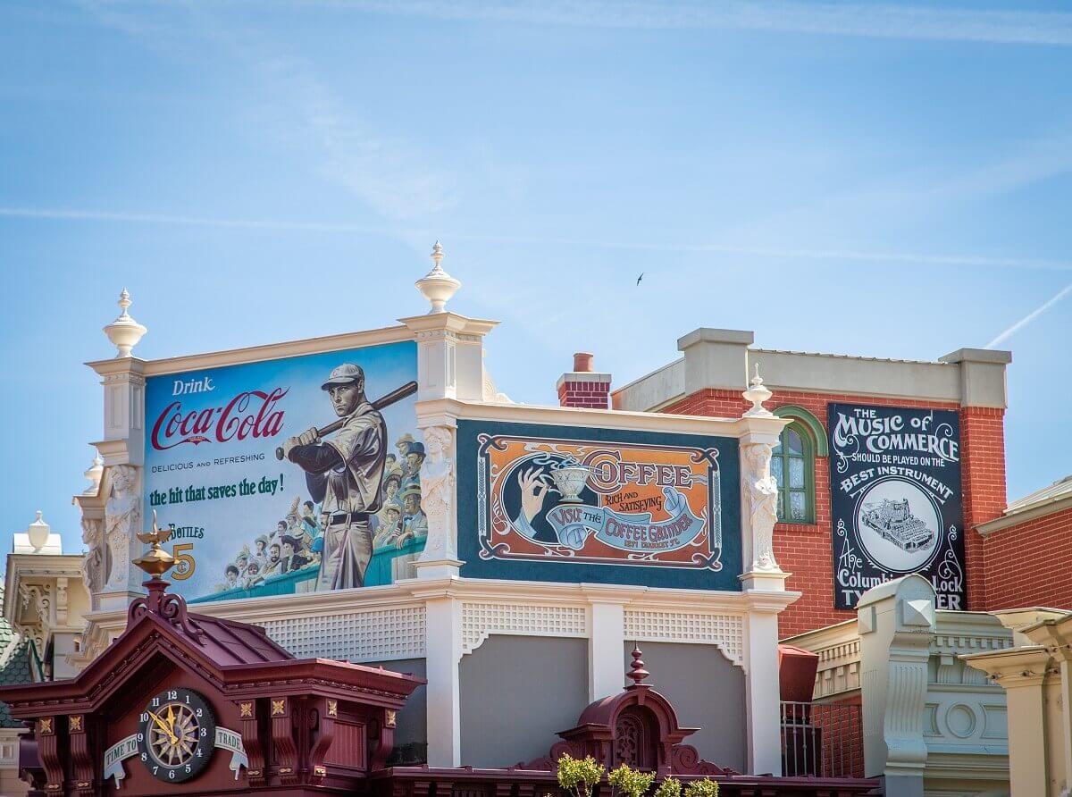 Billboards above Main Street Vehicles Billboards above Main Street Vehicles advertising Coca Cola, The Coffee Grinder & typewriters