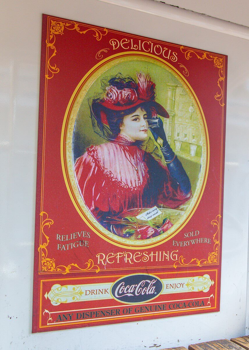 Coca Cola advertising Historical Coca Cola advertisement with a woman in a red costume with advertising message: Relieves Fatigues, Delicious & Refreshing