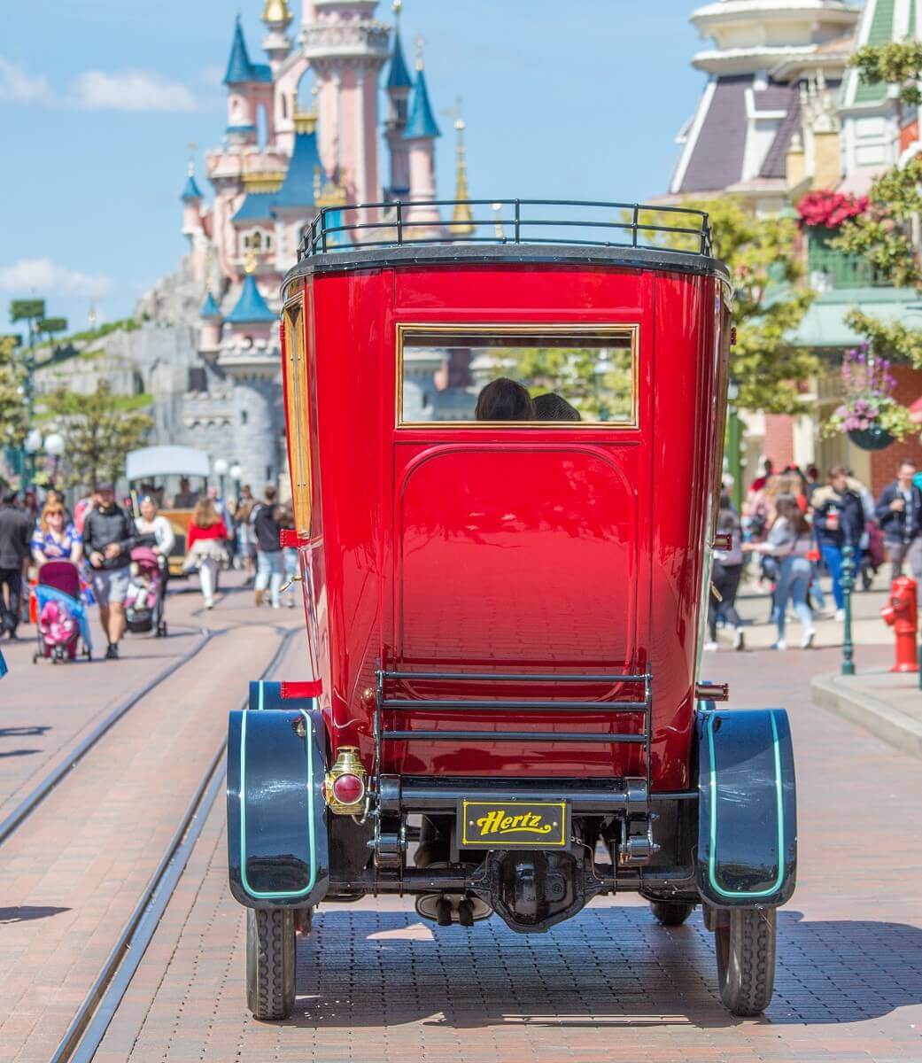 Red oldimer from behind Red Oldimer from behind on the way across Main Street towards Sleeping Beauty Castle