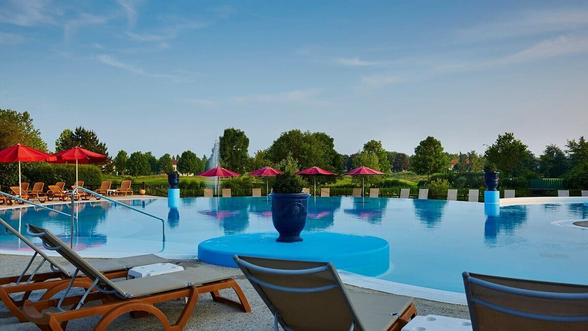 Deck chairs by the pool Sun loungers and parasols line the pool at the Marriott Village Hotel