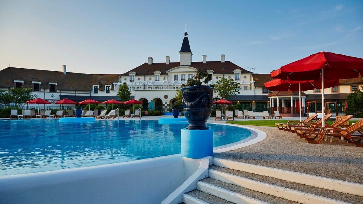 Marriott Village Pool Spacious outdoor pool with sun loungers and parasols at the Marriott Village hotel near Disneyland Paris