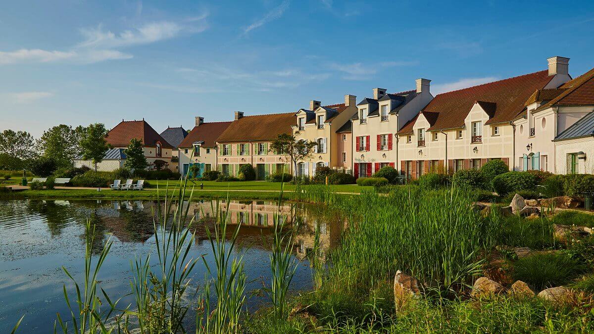 Boardwalk Along the lakeside promenade there are houses in country house style, directly at the lake there are benches and armchairs.