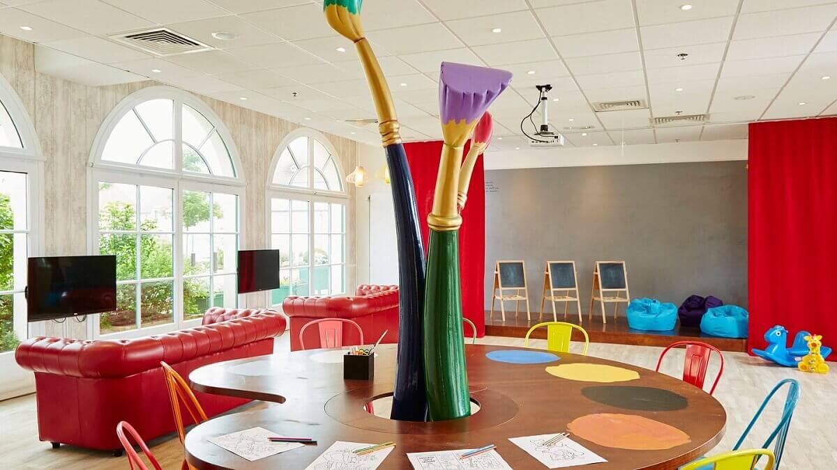 Kids Club Kids Clum at the Marriott Village Hotel with a large craft table for kids, baton bars, beanbags and toys.