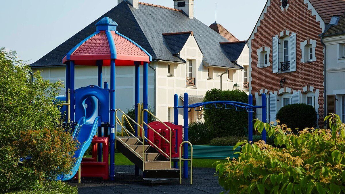 Playground Children's playground with climbing frame and slide in front of Marriott Village holiday homes