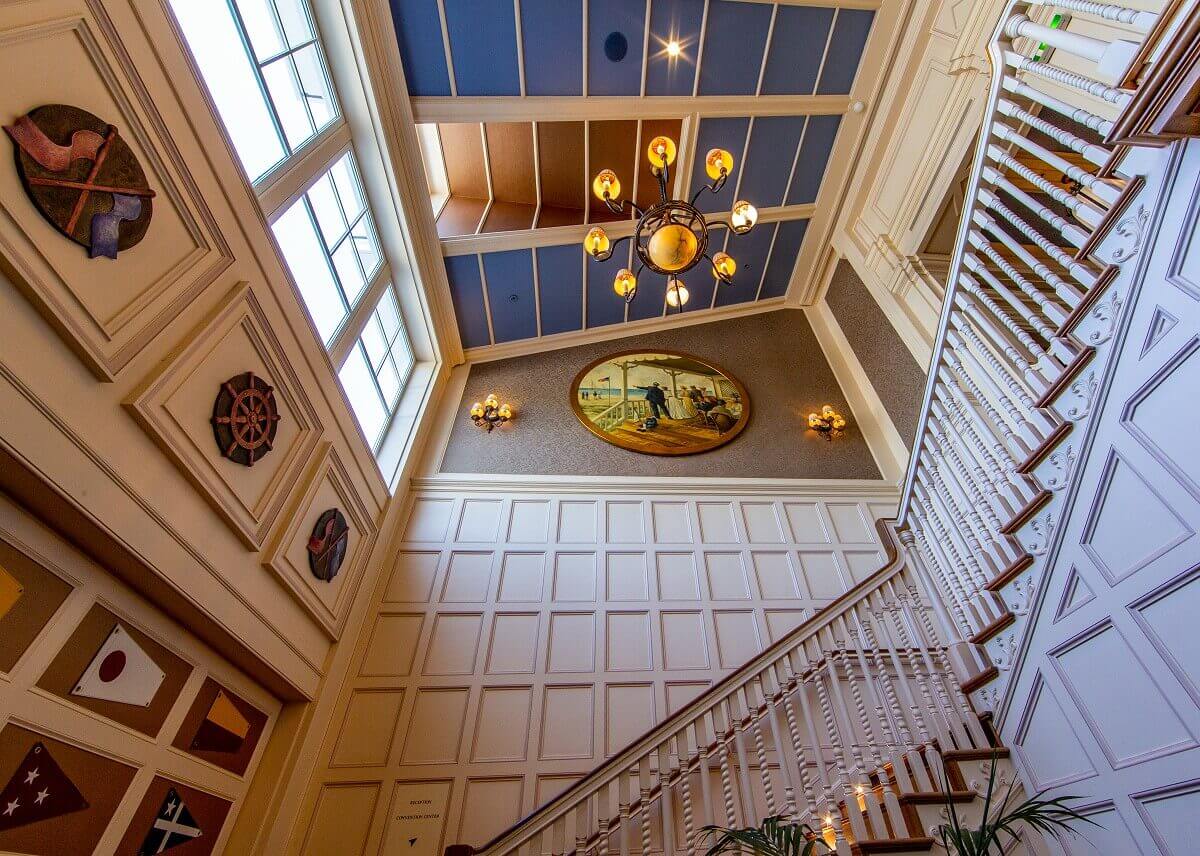 Staircase Hotel Newport Bay Club In a stairwell of the Newport Bay Club hotel, there are shipping symbols on the wall and a chandelier on the ceiling.