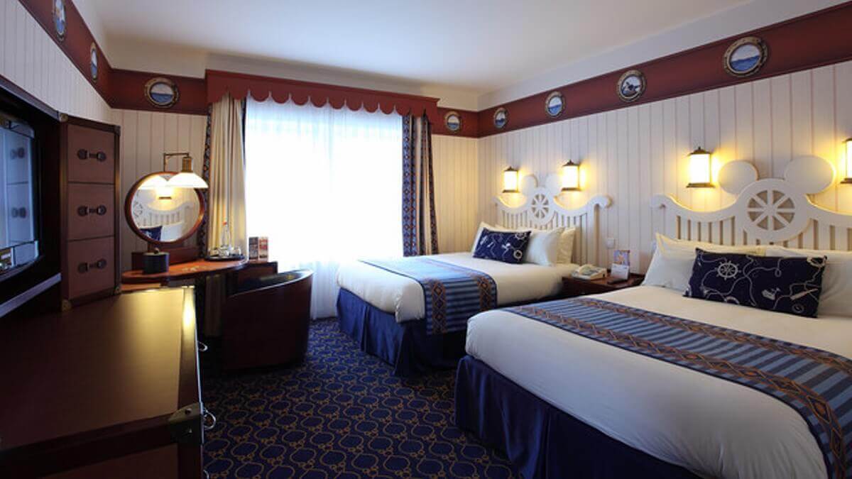 Hotel Rooms Hotel Newport Bay Club View into a hotel room in maritime style with two double beds.