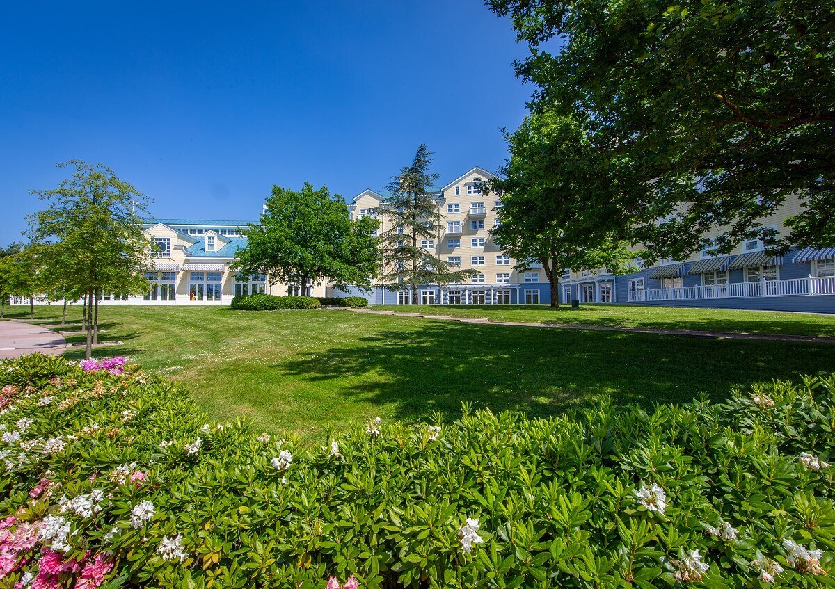 Hotel Newport Bay Club A green area in front of the hotel Newport Bay Club with flowers, shrubs and trees.