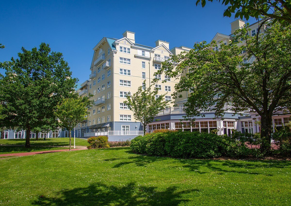 Hotel Newport Bay Club A green area in front of the hotel Newport Bay Club with flowers, shrubs and trees.