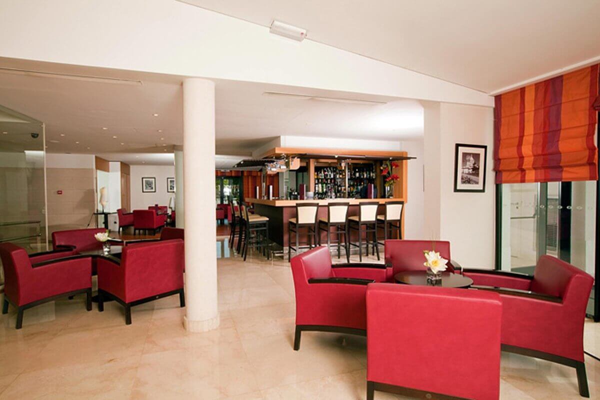 Lounge and bar Bar and lounge at the Residhome Hotel in Val d'Europe with red armchairs and bar stools