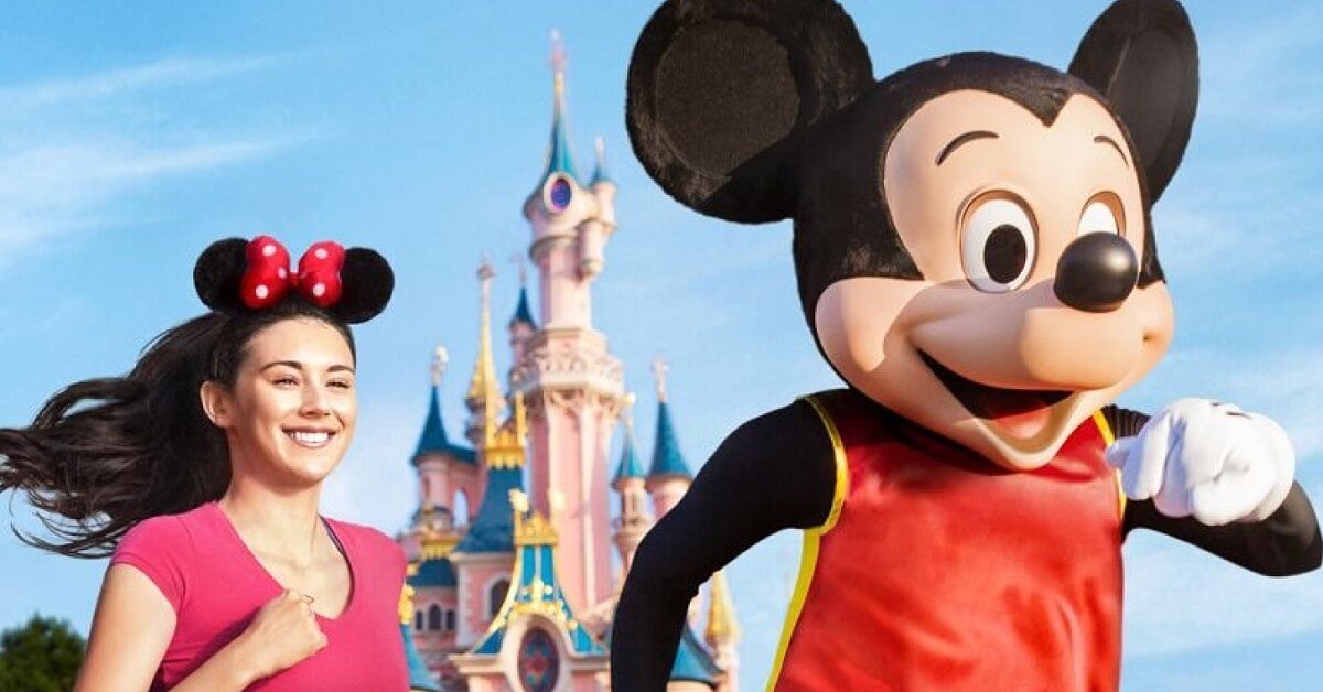 Run Disney Mickey Mouse in sports outfit and a runner at Run Disney for Sleeping Beauty Castle