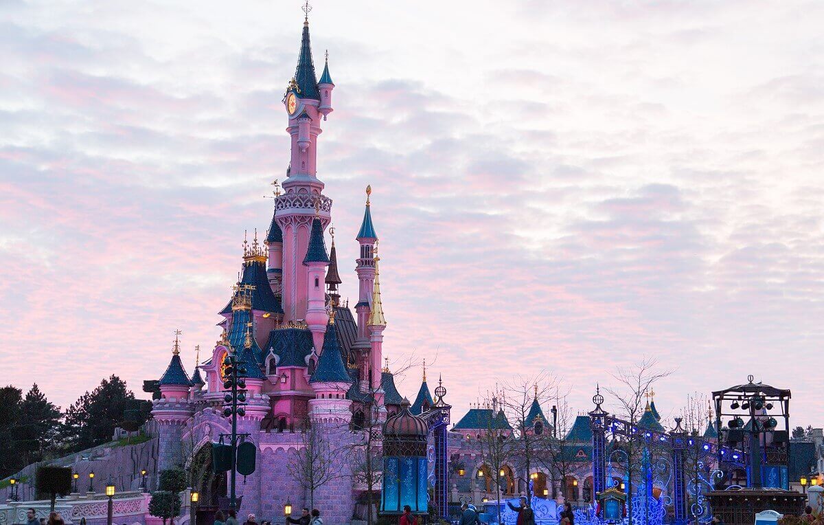 The Dornroeschen castle in the dawn Sleeping Beauty's castle can be seen in front of pink clouds