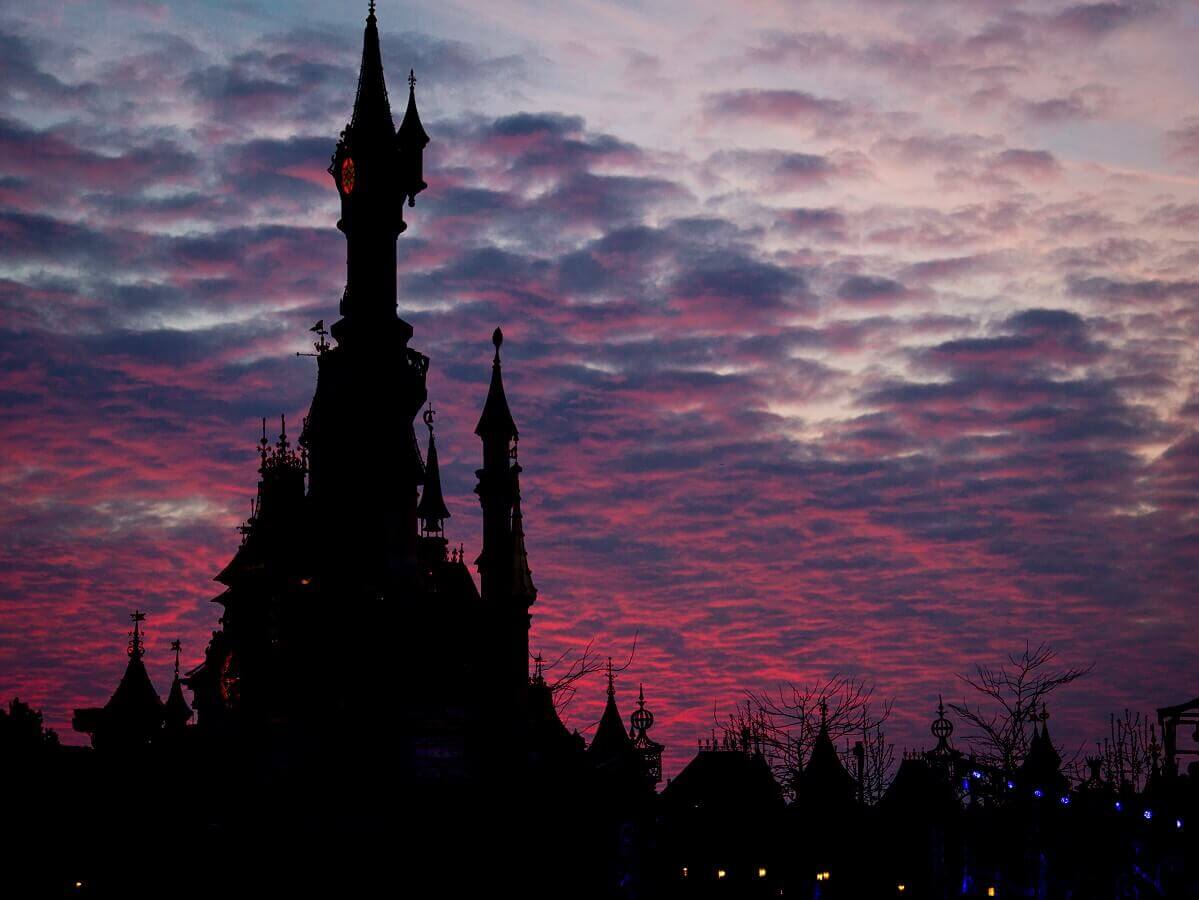 Fairytale evening atmosphere at the castle the outline of the castle can be seen against pink and purple clouds in the twilight