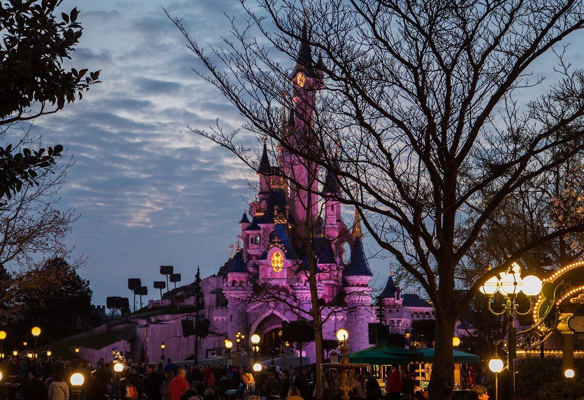 Sunset at Dornroeschen's castle a leafless tree obscures a little the view of the fairy tale castle at sunset