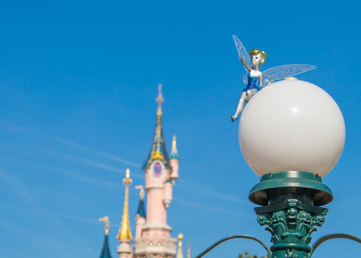 Tinkerbell on a lantern on the round lampshade of a lantern at the big square in front of the castle sits a little Tinkerbell figure