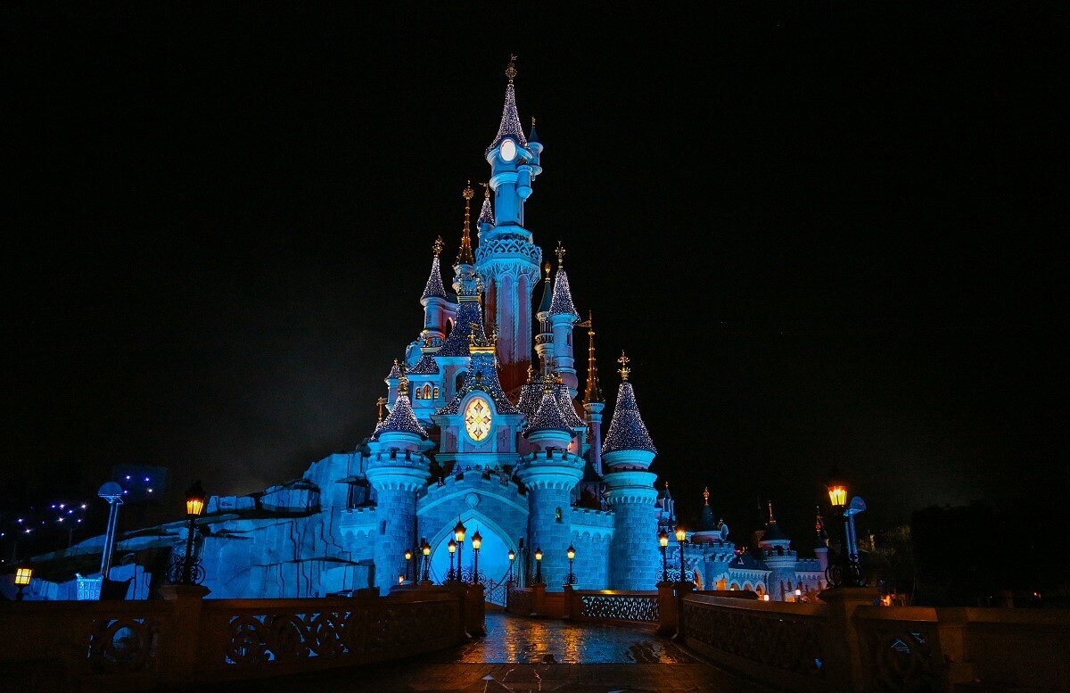 Sparkling castle at night View of the illuminated path to the fairy tale castle glittering at night in the middle of Disneyland Park