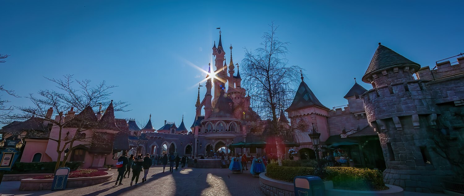 Sleeping Beauty Castle seen from the castle courtyard in the early morning Sleeping Beauty Castle seen from the castle courtyard in the early morning, the sun shines through between the towers