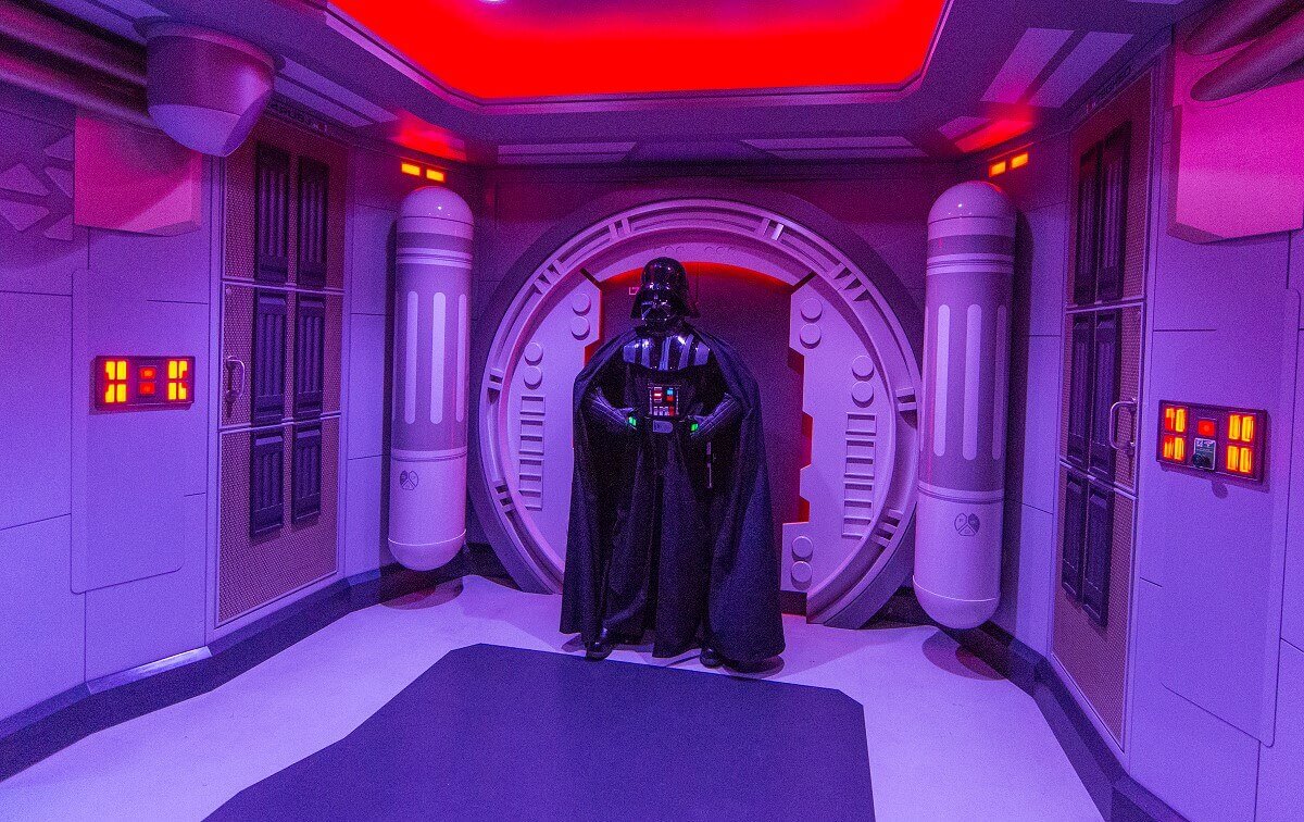 Photo opportunity with Darth Vader Darth Vader poses menacingly in front of a red-lit wall in the starport