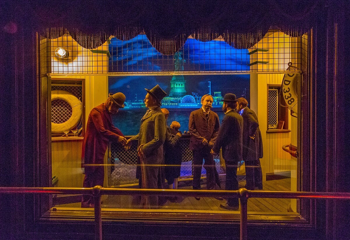 Display in the attraction Display in attraction: people watch the dedication of the Statue of Liberty from aboard a ship