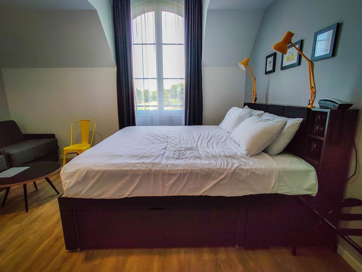 Bed in hotel room View of the king size bed in front of the large window