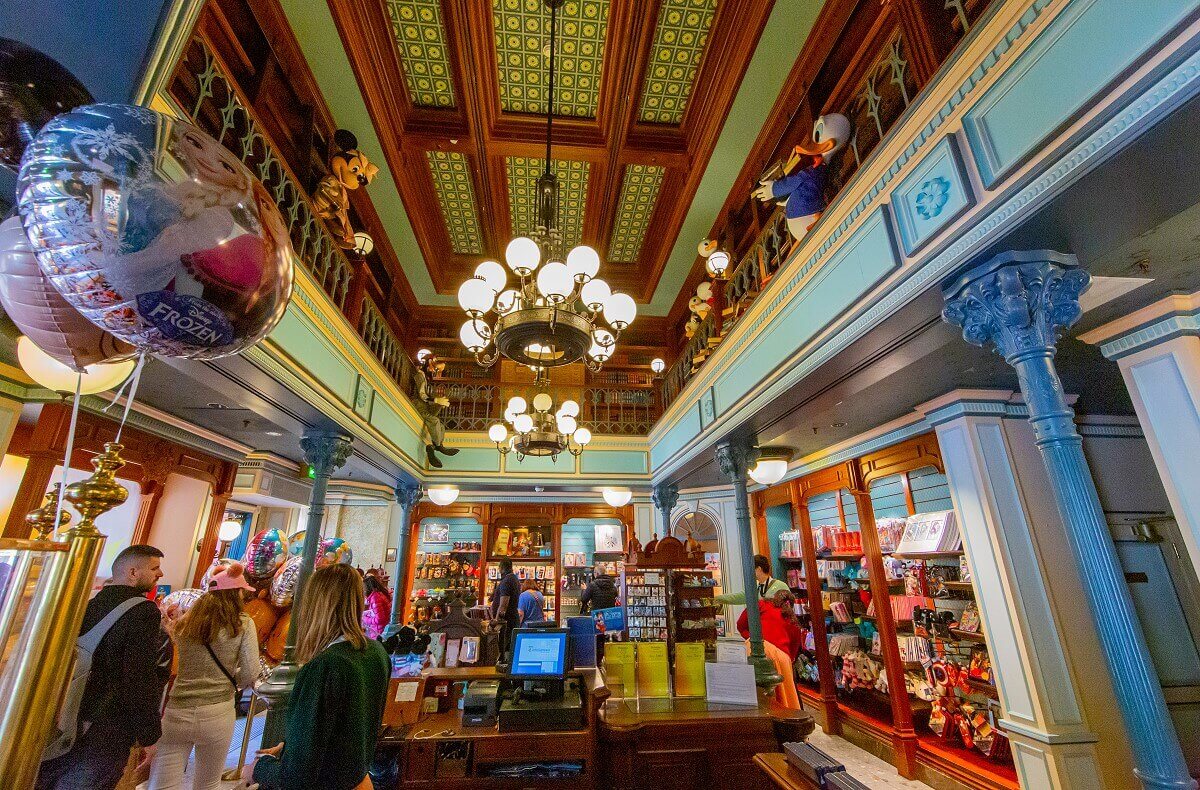 Long shot of the salesroom Long shot of the Storybook Store's salesroom: merchandise can be seen on the ground floor, the gallery surrounding the upper floor is full of bookshelves with Disney characters between them.