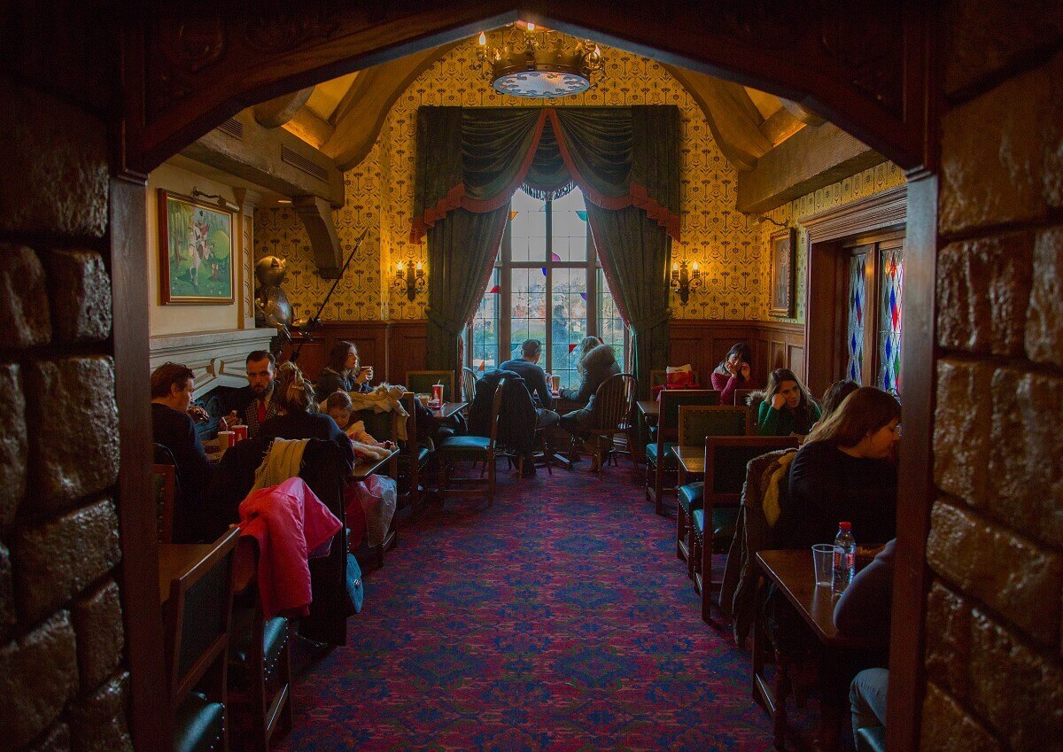 Small dining room View into a small dining room of Toad Hall with heavy green fabric curtains in front of the window