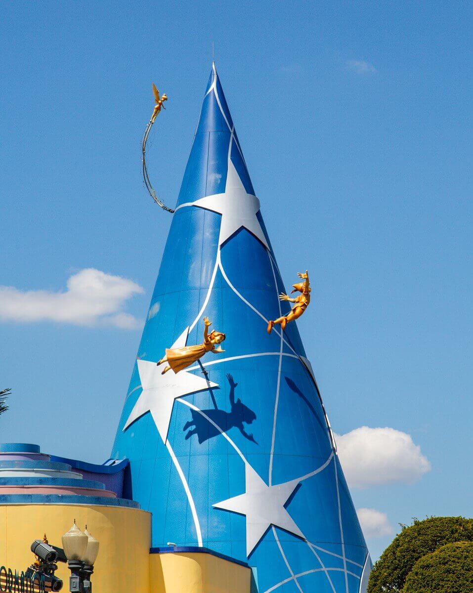 Magic hat with Peter Pan figures Wendy, Peter Pan and Tinkerbell fly around a huge blue magic hat
