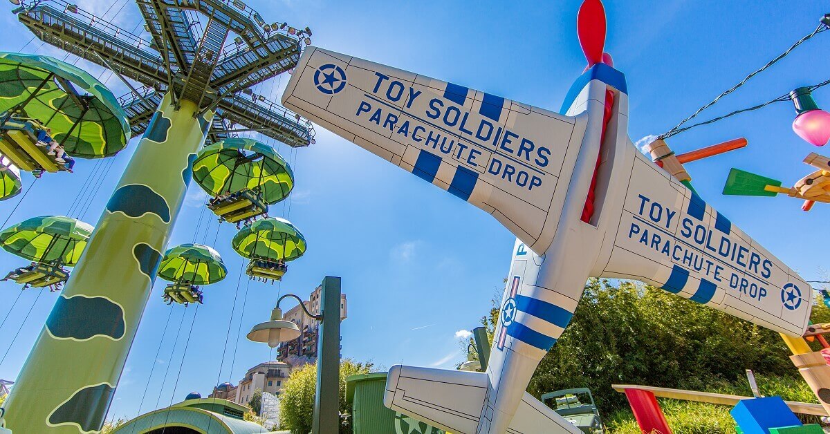 Wide shot of the Toy Soldier Parachute Drop with airplane in the foreground and the Free Fall Tower in the background.