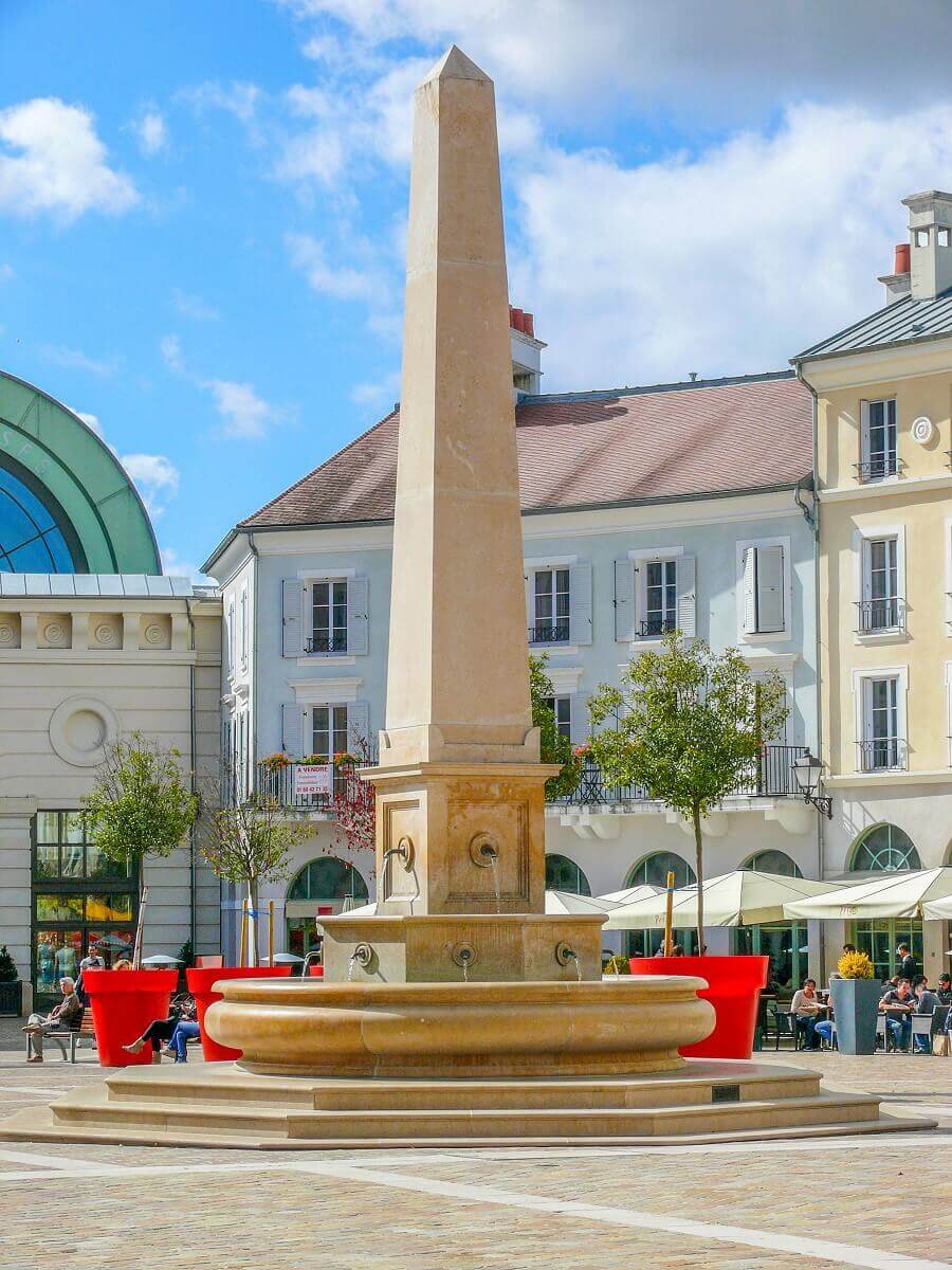 The obelisk at the Place de Toscane The obelisk at the Place de Toscane, on the left behind it the entrance of the Val d'Europe shopping center can be seen