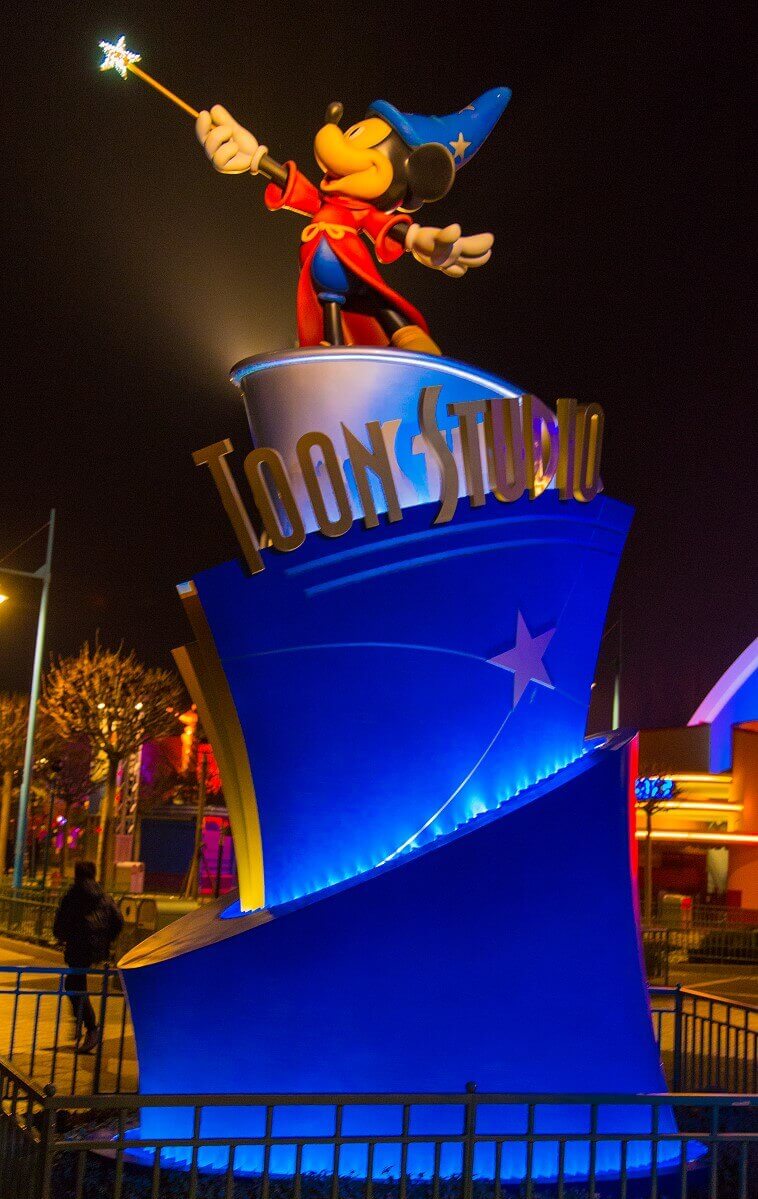 The luminous entrance sign of Toon Studios The glowing entrance sign of Toon Studios in the look of a wave, on which Mickey stands as a sorcerer's apprentice with a glowing magic wand