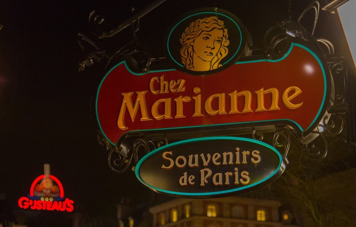 Chez Marianne Sign of the shop Chez Marianne - Souvenirs de Paris, in the background the illuminated sign of Gusteau's